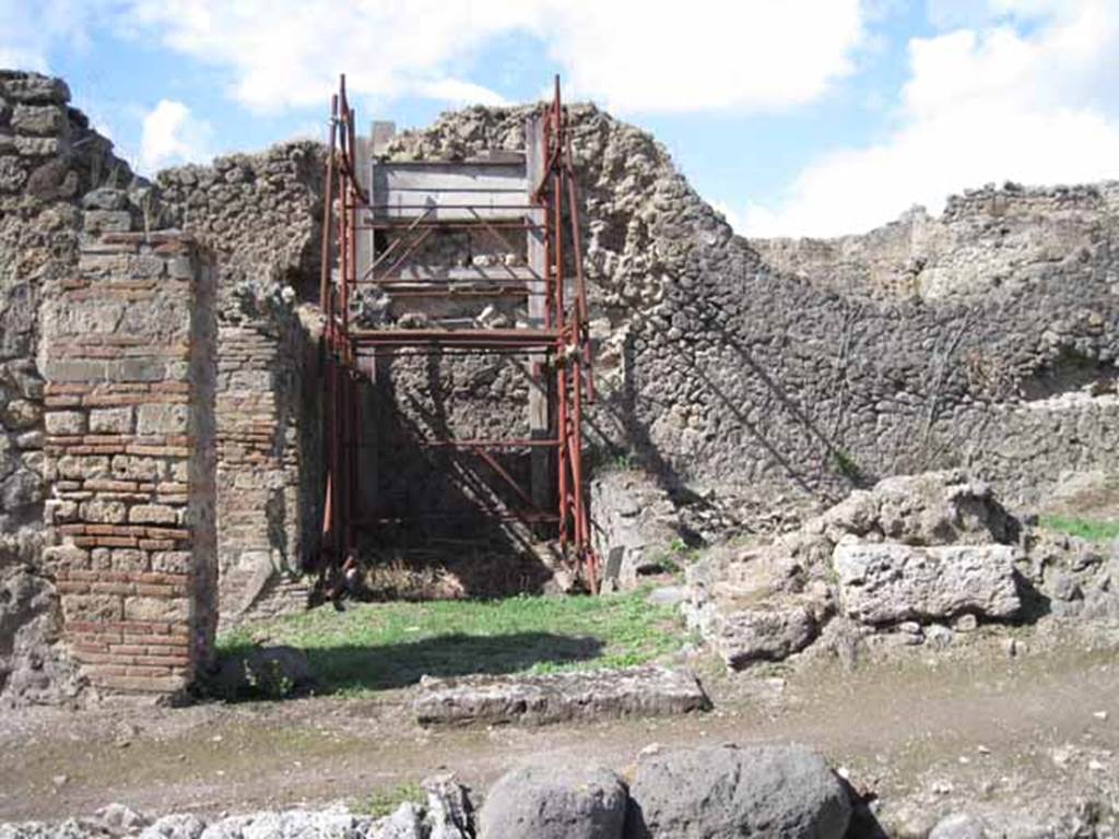 I.2.31 Pompeii. September 2010. Looking north to entrance doorway (cill or threshold still there). The green grassed area would have been one rear room of the bar at I.2.1. The other rear room would have been where the scaffolding is now. Photo courtesy of Drew Baker.
