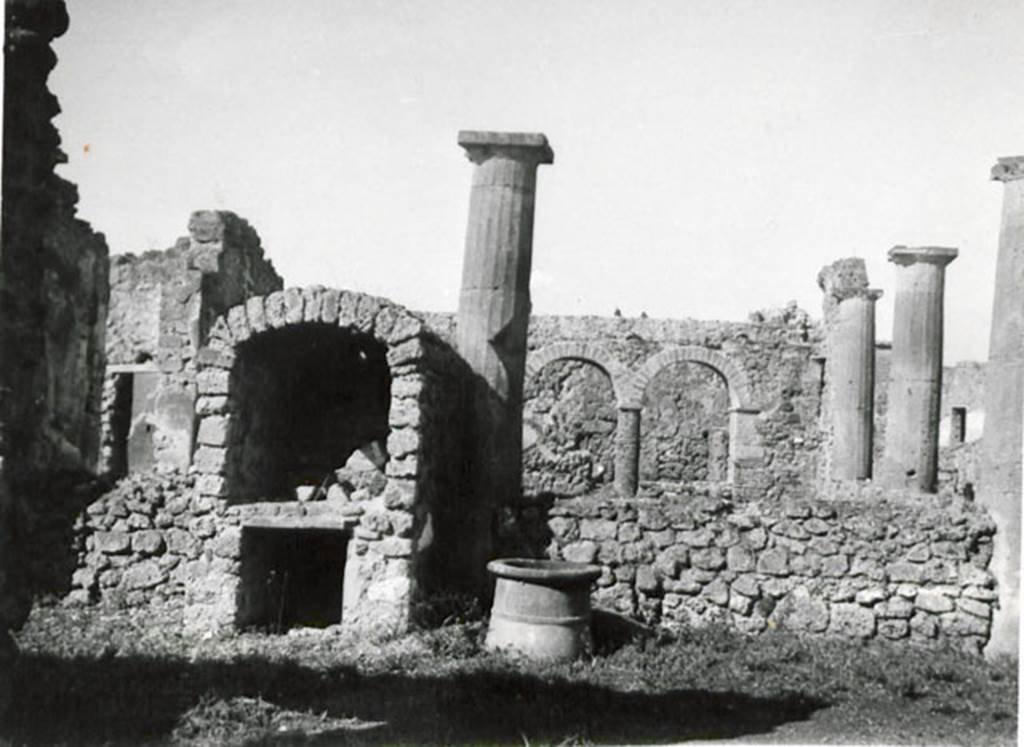I.3.8b Pompeii. 1935 photograph taken by Tatiana Warscher, taken from the east. 
See Warscher, T, 1935: Codex Topographicus Pompejanus, Regio I, 3: (no.16a), Rome, DAIR, whose copyright it remains.  
According to Warscher, 
This house was not without interest. The tufa Doric columns of the peristyle had been joined  later  by a wall between them. The west side of the portico consisted of brick columns surmounted by arches. Above these arches was a walkway. The north wall ended in a vault.
