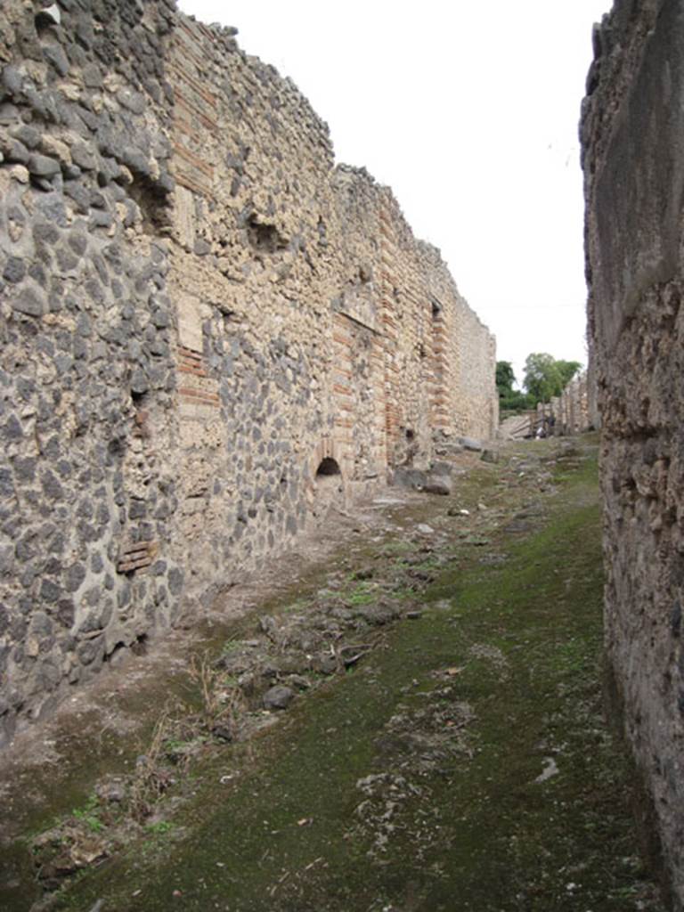 I.3.31, on left, Pompeii. September 2010. Looking east from outside property. Looking along south exterior wall towards blocked doorway, and towards I.3.30. Photo courtesy of Drew Baker.
.
