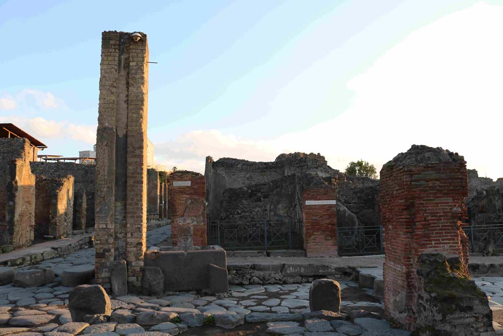 I.4.15 Pompeii. December 2018. Looking east across Holconius crossroads on Via Stabiana, towards I.4.15 behind fountain at south-east corner of crossroads. 
Photo courtesy of Aude Durand.
