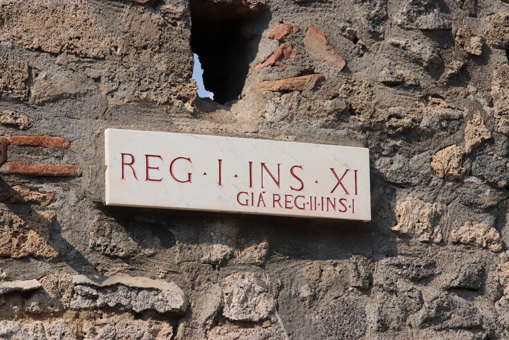 I.11.11 Pompeii. October 2022. 
Identification plate on west side of entrance doorway, originally known as Reg. II. Insula 1, now Reg. I. Insula XI. Photo courtesy of Klaus Heese.

