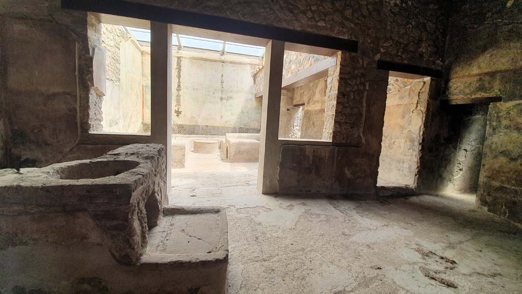 I.11.16 Pompeii. July 2021. Room 3, bar-room/atrium.
Looking east towards the bar-counter, with the larger of the two openings in the bar-counter, on left, and hearth beneath.
Foto Annette Haug, ERC Grant 681269 DÉCOR.
