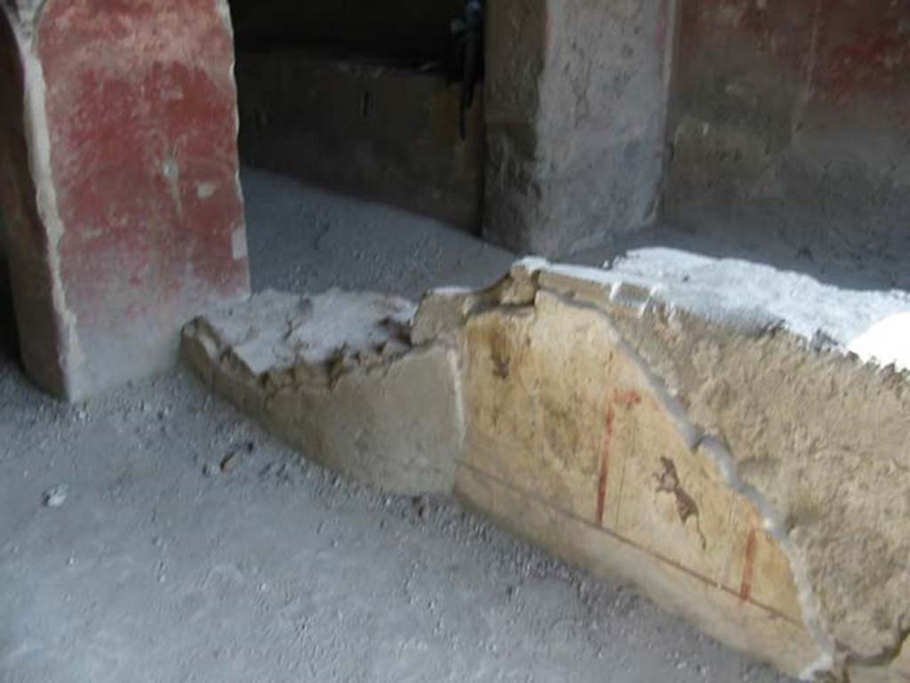 I.12.3 Pompeii. May 2003. Remains of painted plaster at end of counter on east side. Photo courtesy of Nicolas Monteix.