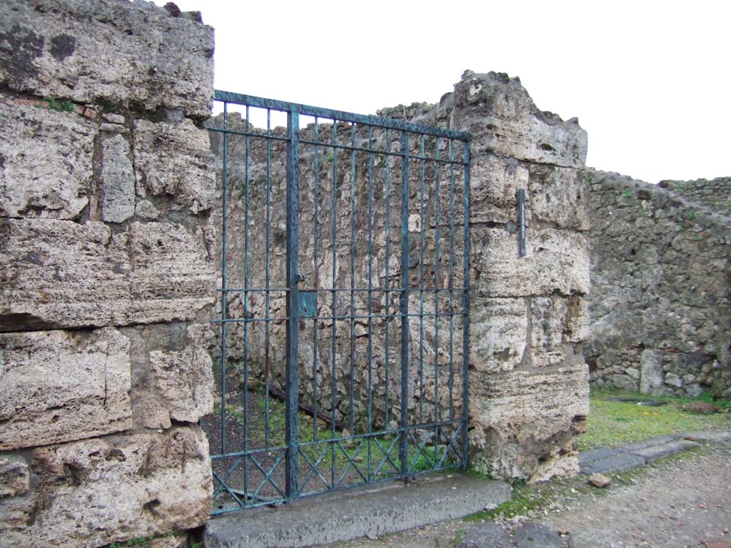 V.1.18 Pompeii. December 2005. Entrance doorway. Graffiti was found on the pilaster to the left of the doorway, see V.1.17.
On the pilaster on the south side of the doorway, on the right, the following graffiti were found:

Daphnicus cum Felicla sua hic    [CIL IV 4066] 
This was scribbled to the right of the entrance and translates as “Daphnicus was here with his Felicula”
According to Varone, another graffito, possibly by or for this same couple, was found near the doorway of house VI.13.19 [CIL IV 4477]
See Varone, A., 2002. Erotica Pompeiana: Love Inscriptions on the Walls of Pompeii, Rome: L’erma di Bretschneider. (p.46)

According to Della Corte, found on the same pilaster (to the right) was:
Popidium  Secundum
aed(ilem)  d(ignum)  r(ei)  p(ublicae)  probissimum  iuvenem  o(ro)  v(os)  f(aciatis)
Rufine  fave  et  ille  te  faciet      [CIL IV 3409]
See Della Corte, M., 1965. Case ed Abitanti di Pompei. Napoli: Fausto Fiorentino. (p.99)
