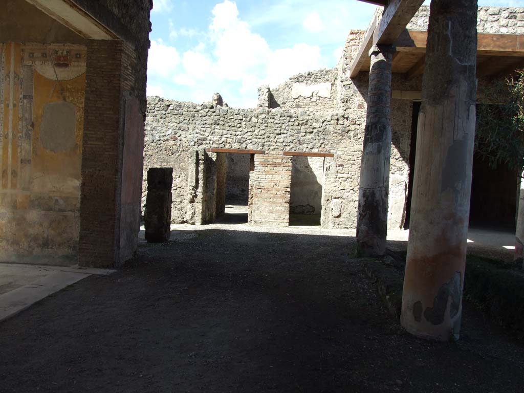 V.1.26 Pompeii. March 2009. Looking north across west portico area, towards passageway to V.1.23, centre left.