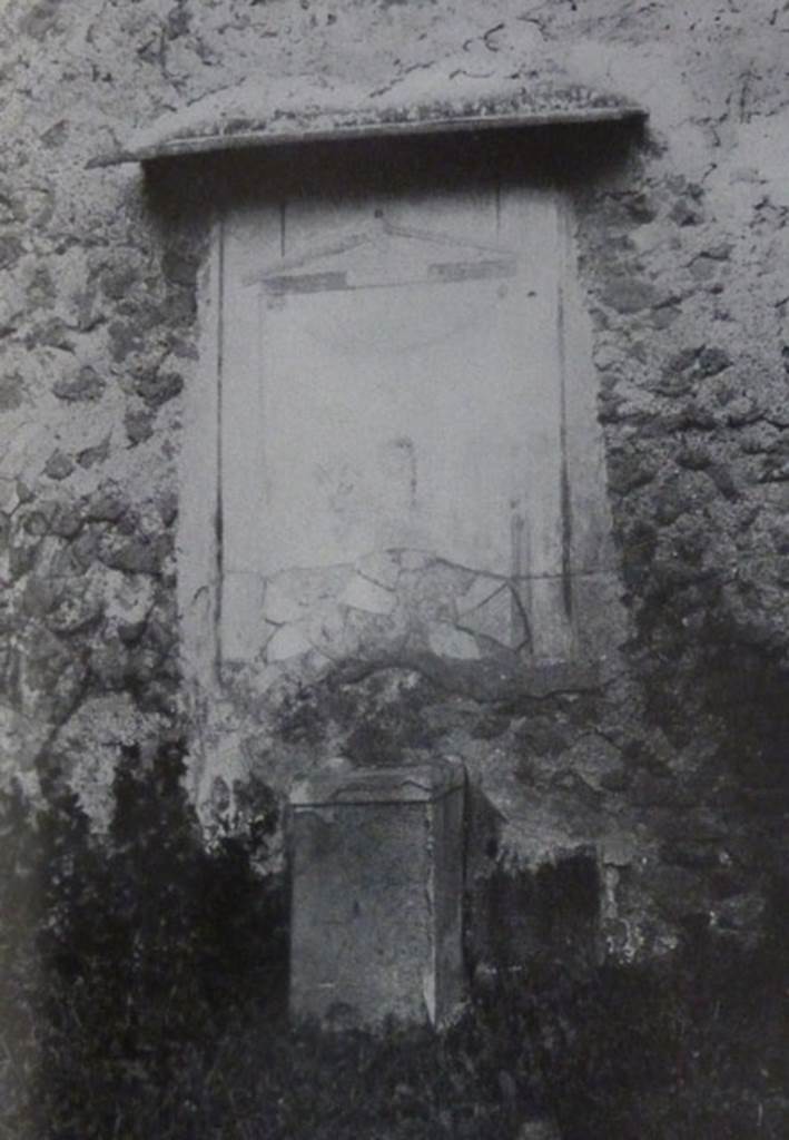 V.2.15 Pompeii. Old undated photograph. Garden 11c. North wall. Lararium.
The Notizie degli Scavi records a panel of white stucco.
On this is painted an aedicula, which Boyce says is painted in blue, yellow, dark red and green.
Within the aedicula is a painting of Giove (Jupiter) seated on a throne.
Underneath is a masonry altar covered with white plaster. 
See Notizie degli Scavi di Antichit, 1894, p. 439.
See Boyce G. K., 1937. Corpus of the Lararia of Pompeii. Rome: MAAR 14.  (96, p.35, Pl 39,3).
