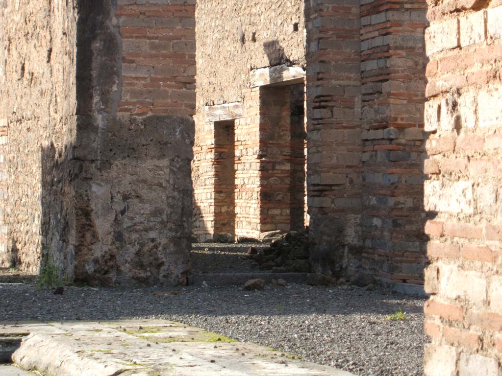 VI.13.13 Pompeii. December 2004. 
North-west corner of atrium, with doorway to oecus containing a corridor to the rear rooms.
The doorways to the kitchen and latrine, and a storeroom can be seen.

