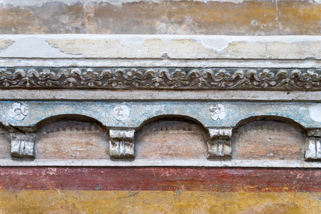 VI.15.1 Pompeii. March 2023. Detail of stucco below lararium painting. Photo courtesy of Johannes Eber.