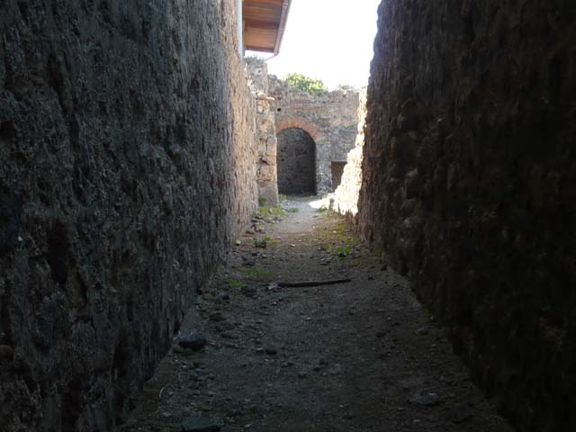 VII.1.8 Pompeii . December 2006. Corridor running south along rear of VII.1.52 to VII.1.58 on right. On the left is the rear wall of the baths, nymphaeum G, pool D and nymphaeum F. Underneath is an underground corridor running from rooms T and U to an underground storeroom V. This is an irregular shaped room carved into the stone below the pool D. Originally it was probably a tomb dating back to 6th or 7th century B.C.
