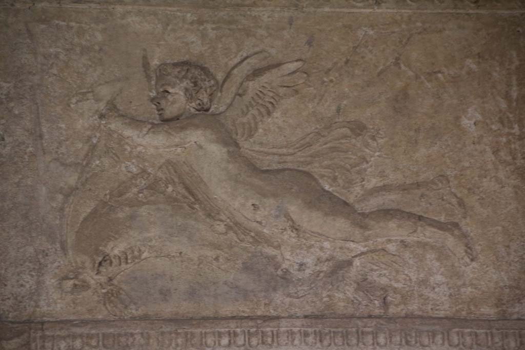 VII.1.8 Pompeii. April 2014. Detail of stuccoed cupid with dolphin from south end of east wall of men’s changing room 2. 
Photo courtesy of Klaus Heese. 
