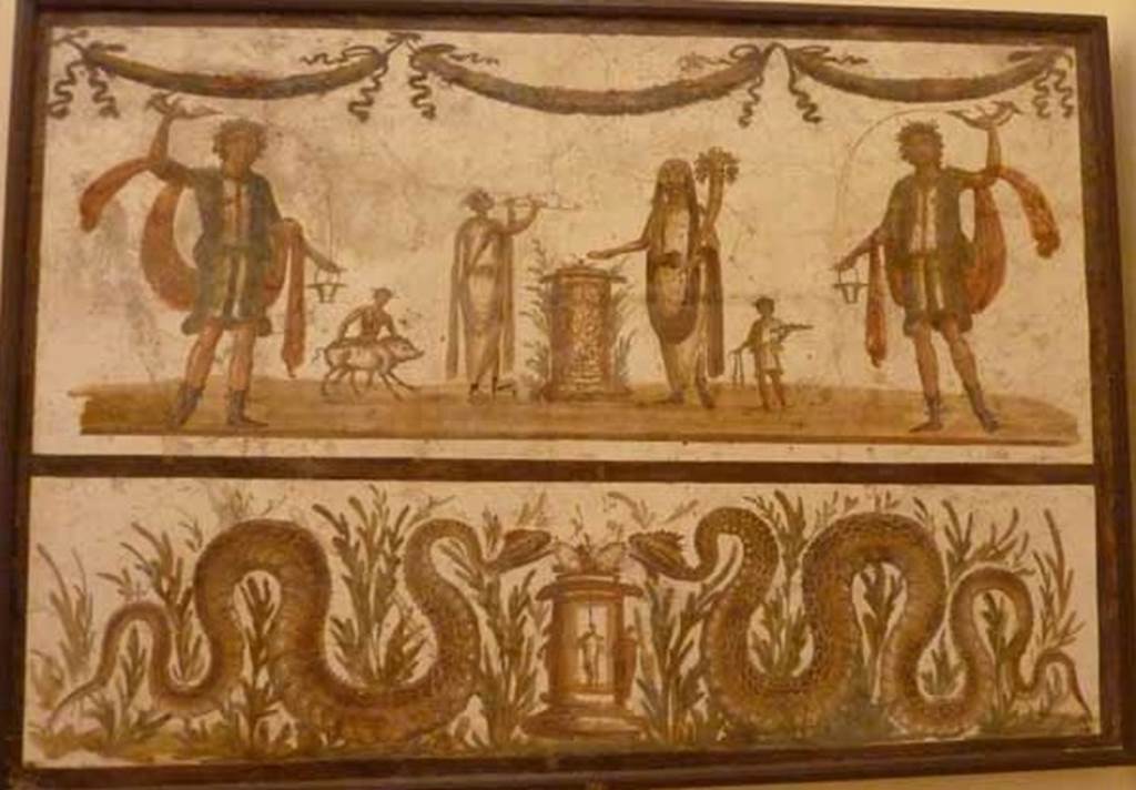 VII.6.38 Pompeii. May 2010. Lararium painting. The upper part has an offering scene.  A round altar is in the centre.  The offering Genius has a small camillus helping on his right.  On the other side of the altar is the tibicen with a popa assisting with a small pig.  The scene is flanked on either side by a large lar.  Above the scene are three garlands. The lower part has two serpents, in plants, approaching a second round altar, one from either side. Frhlich says this as found  Reg.  VII or VIII.  
See Frhlich, T., 1991. Lararien und Fassadenbilder in den Vesuvstdten. Mainz: von Zabern. (L98, T: 10,2).
Pagano and Prisciandaro show this as being from VII.6.38.
See Pagano, M., and Prisciandaro, R., 2006. Studio sulle provenienze degli oggetti rinvenuti negli scavi borbonici del regno di Napoli.  Naples : Nicola Longobardi.  (p.39).
Now in Naples Archaeological Museum. Inventory number: 8905.
