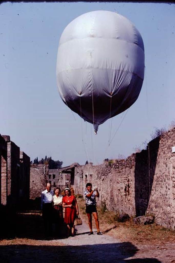 Via di Castricio, Pompeii. 1974. Looking west towards Stanley, Wilhelmina, Prof. Cerulli-Irelli and the balloon.  Photo by Stanley A. Jashemski.   
Source: The Wilhelmina and Stanley A. Jashemski archive in the University of Maryland Library, Special Collections (See collection page) and made available under the Creative Commons Attribution-Non Commercial License v.4. See Licence and use details. J74f0496
