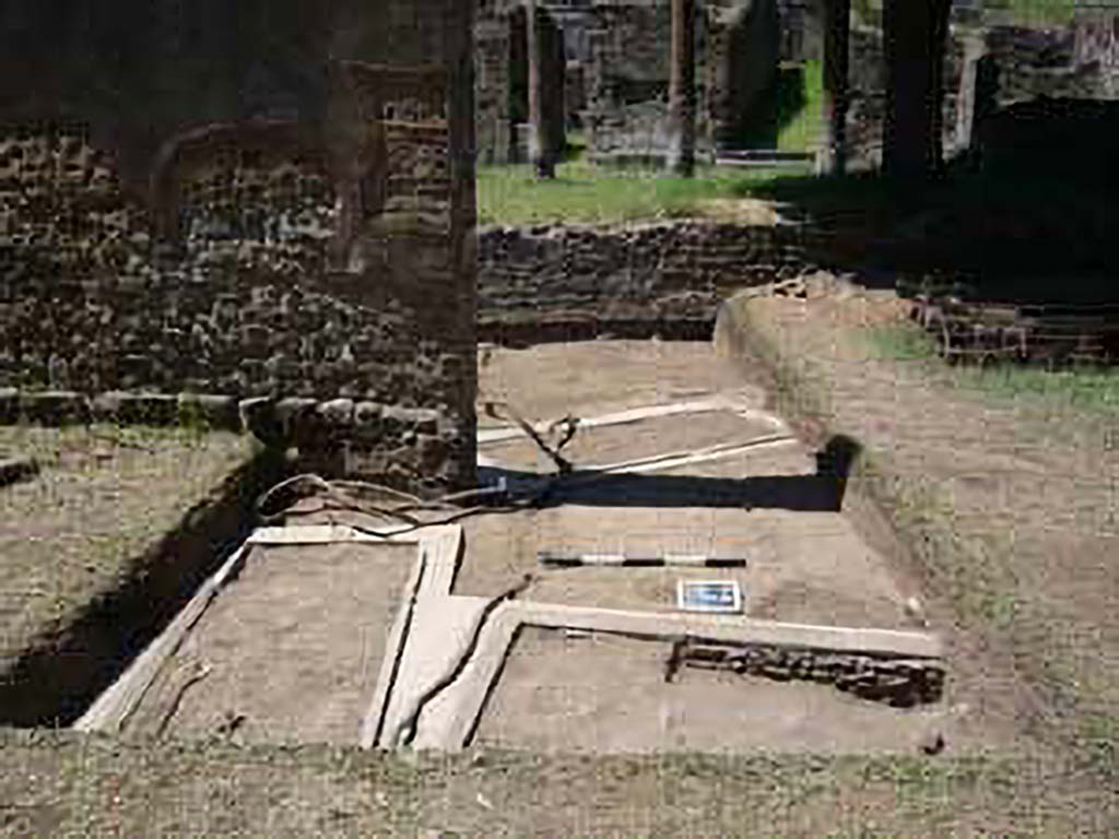 HGE15A Pompeii. 2009 re-excavation of three Samnite graves by the Via Consolare Project. 
The location of three graves is clustered around the base of the wall. 
The two graves in the metal frames are also visible on the other side of the gap in the wall.
Excavations in 2009 were carried out by the Via Consolare Project and their report commented that:
Extensive modern deposits were removed from the area, revealing three heavily reconstructed, irregularly-aligned inhumation cist-graves. 
It is likely that these constructions are the result of the excavations of A. Maiuri in the 1930-40s and were a component of his preparations of the Villa for general display that included replanting the viridarium and running water to the nymphaeum.
Photo courtesy of the Via Consolare Project. See http://www.viaconsolareproject.org/research2009.html
