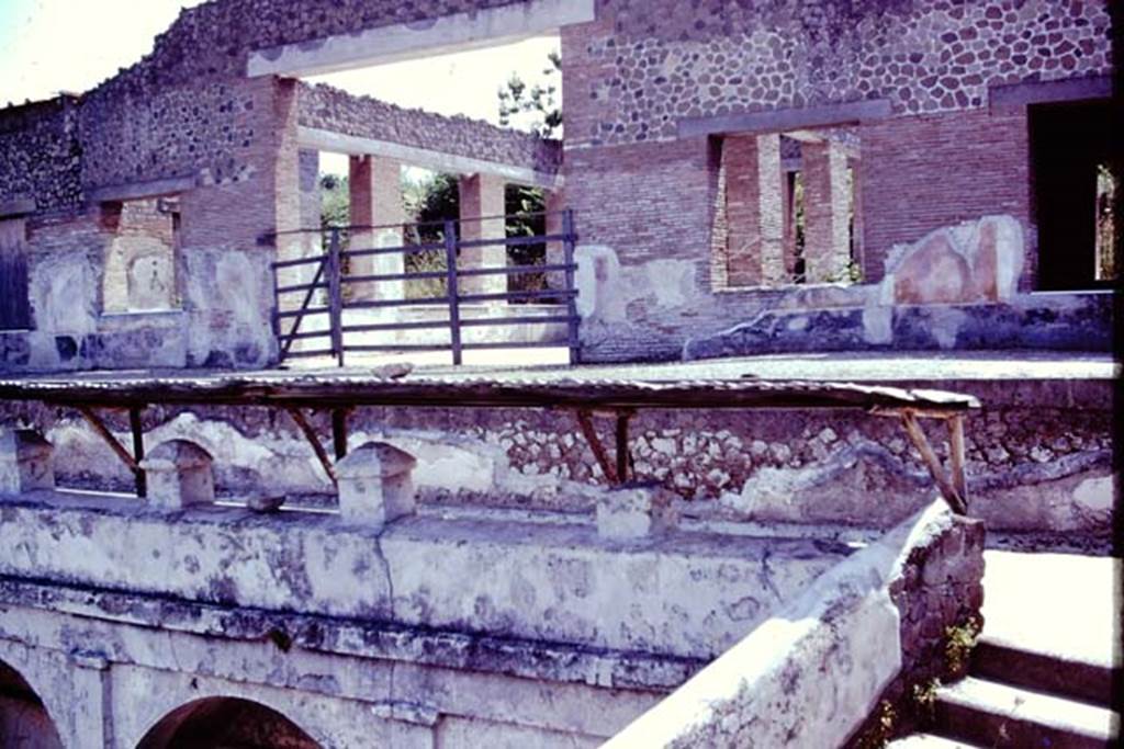 Villa Arianna, 1976. Looking towards the summer triclinium. In front of the fine rooms of the Villa, designed to take advantage of the view, was a portico but only one column remains from it, and a balustrade. On the right, at the side of the balustrade, the steps and a ramp would have led down to the two terraces and to the seashore. Photo by Stanley A. Jashemski.   
Source: The Wilhelmina and Stanley A. Jashemski archive in the University of Maryland Library, Special Collections (See collection page) and made available under the Creative Commons Attribution-Non Commercial License v.4. See Licence and use details. J76f0517
