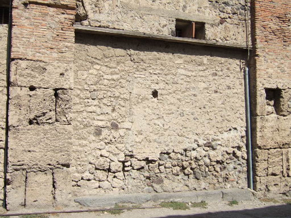 VII.5.15 Pompeii. September 2005. Looking north towards site of doorway to shop.According to Garcia y Garcia, all of the south-west corner and southern part of the insula were transformed in the time of Maiuri.Then the area was hit during the first bombing incursion during the early evening (17.00hrs) of 13th September 1943. All of the old structures that remained have been modified again to provide a restaurant, toilets and sales area. The modifications included closing and bricking up of the old doorways to VII.5.14, 15, 16 and 17. Entrances at VII.5.18, 19 and 20 now provide the doorways to the modern restaurant.  See Garcia y Garcia, L., 2006. Danni di guerra a Pompei. Rome: L’Erma di Bretschneider. (p.101-3).

On the pilaster between VII.5.14 and VII.5.15, on the left, a painting of two gladiators was found in April 1817. Remaining on the pilaster, it gradually faded. Fiorelli said it was almost vanished when he saw it.  
See Jacobelli, L., 2003. Gladiators at Pompeii. Rome: L’Erma di Bretschneider. (p. 79) See Helbig, W., 1868. Wandgemälde der vom Vesuv verschütteten Städte Campaniens. Leipzig: Breitkopf und Härtel. (1513)

Below the painting of the gladiators were inscriptions painted in red, found 12th April 1818 –
Tetraites  Prudes  Prudes  l(udes)  XIIX  Tetraites  l(udes)  X[…]
abiat  Venere  <P=B>ompei{i}ana( !)  iratum  qui  hoc  laesaerit     [CIL IV 538]
Marcellum  aed(ilem)  EAMH()  roga(t)     [CIL IV 539]
See Pagano, M. and Prisciandaro, R., 2006. Studio sulle provenienze degli oggetti rinvenuti negli scavi borbonici del regno di Napoli.  Naples : Nicola Longobardi.  (p.116)

According to Boyce, in the main room was a lararium painting on a white background. Either side of an altar stood the Genius and the tibicen, both of the same size, behind the Genius was a large cock. On each side of this group stood a Lar of larger stature than the Genius, wearing green and yellow tunics with red pallium. In the zone below were two serpents moving towards an altar furnished with offerings.
See Boyce G. K., 1937. Corpus of the Lararia of Pompeii. Rome: MAAR 14. (p. 67, no.285). 

According to Fiorelli, this was a shop with two rooms, in the first room was the Lararium, in the second room was a vast latrine.
See Pappalardo, U., 2001. La Descrizione di Pompei per Giuseppe Fiorelli (1875). Napoli: Massa Editore. (p.96)




