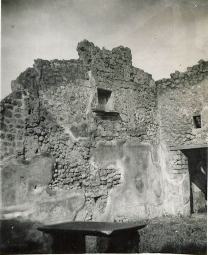 I.3.24 Pompeii. 1935 photograph taken by Tatiana Warscher. According to Warscher,
La situazione della nicchia pone la questione  se nellatrio vi fosse oltre al piano terreno anche un primo piano giacch essa  situata troppo in alto. I pochi avanzi pittorici sulla parete occidentale fanno pensare ad imitazione del primo stile, che la parete cio fosse mediante fasce divisa in rettangoli oblunghi. Lesempio di questa imitazione del primo stile o primo stile semplificato pu vedersi nellatrio della casa del Principe di Napoli (VI.15.7/8).
Sopra la porta del cubicolo v una piccola finestra.
See Warscher, T, 1935: Codex Topographicus Pompejanus, Regio I, 3: (no.53), Rome, DAIR, whose copyright it remains.  
(translation: "The situation of the niche raised the question  if in the atrium there was ever an upper floor as the niche was located too high. A few painted remains on the west wall suggested an imitation of the first style, divided into bands by rectangular oblongs.  The example of this imitation of the first style or "first simplified style" can be seen in the lobby of the Casa del Principe di Napoli (VI. 15.7/8).  Over the doorway of the cubiculum there was a small window ".
