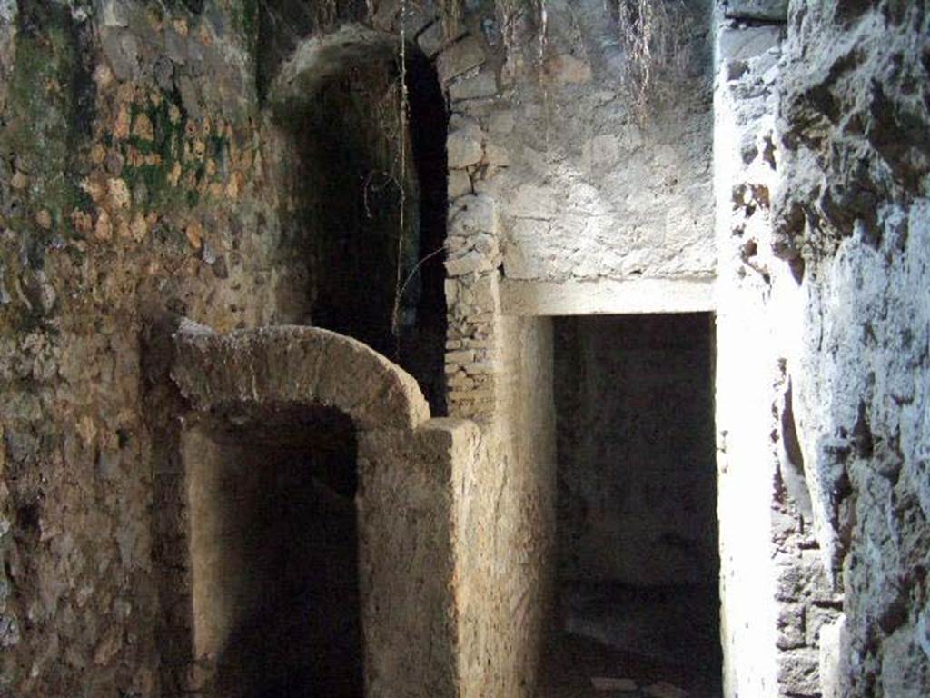 I.6.2 Pompeii. May 2006. Anteroom, apodyterium or changing room on south side of frigidarium, at end of corridor. Looking west towards arched entrance to area under stairs, and doorway into passage leading to east wing of cryptoporticus. The arched doorway into the frigidarium can be seen in the north wall, on the right side. According to Peters, on the north and south walls of the passageway, badly preserved landscapes were found. See Peters, W.J.T. (1963): Landscape in Romano-Campanian Mural Paintings.The Netherland, Van Gorcum & Comp. (p.23)