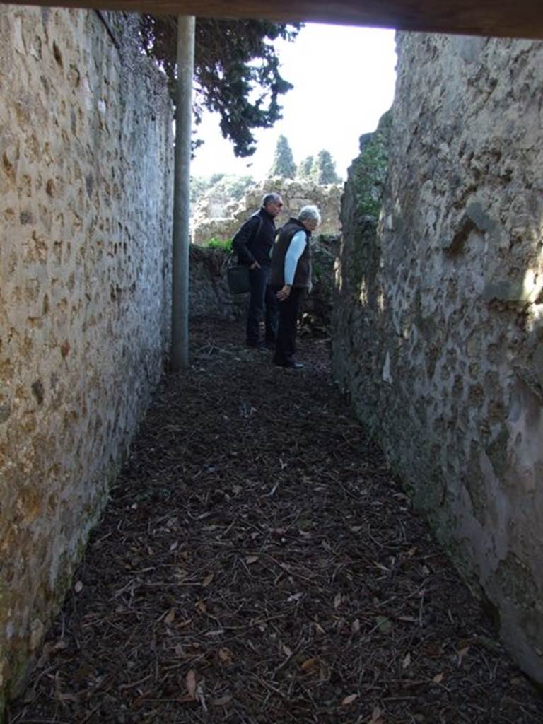 I.10.4 Pompeii. March 2009. Corridor M1 looking west to room 26 a latrine at the end of the corridor, with entrance to kitchen, room 27, on right.

