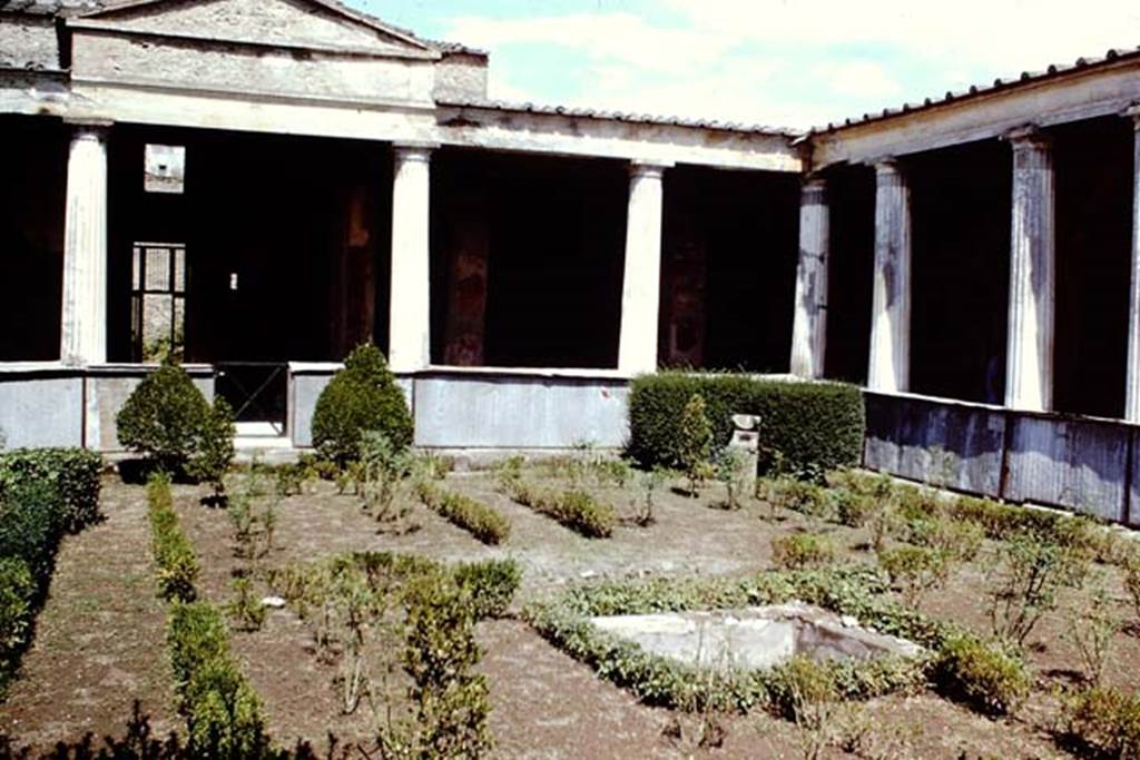 I.10.4 Pompeii, 1968. Looking towards north and north-east corner of peristyle. Photo by Stanley A. Jashemski.
Source: The Wilhelmina and Stanley A. Jashemski archive in the University of Maryland Library, Special Collections (See collection page) and made available under the Creative Commons Attribution-Non-Commercial License v.4. See Licence and use details.
J68f1001
According to Jashemski –
“The imprint of a wooden triclinium, which occupied a rectangular area 1.74 x 2.69m, was found in the garden, and on the south side of the triclinium was a square pool with a fountain. There was a spherical sundial in the north-east of the garden”.
See Jashemski, W. F., 1993. The Gardens of Pompeii, Volume II: Appendices. New York: Caratzas. (p.47).

According to Soprano –
Ubiczione: peristilio.
Bibliog. Maiuri, La Casa del Menandro e il suo tesore di argenteria. (Roma, 1939), p.84 and fig.a on p.75.
Nel peristilio furono rinvenute le impronte di un triclinio ligneo. 
Occupava un’area rettangolare di m.1.74 per 2.69; ad ovest del triclinio c’era una piscina quadrata.
See Soprano, P. (1950). I triclini all’aperto di Pompei. (In Pompeiana, raccolta di studi per il secondo centenario degli scavi di Pompei. Napoli, Gaetano Macchiaroli, Editore, P. 307, no.31).

