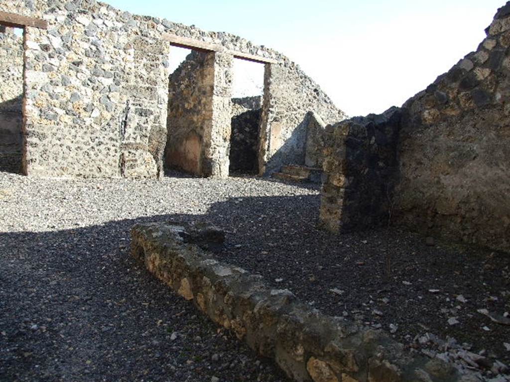 I.11.15 Pompeii. December 2006. Remains of low wall of room 3 on south side of entrance.