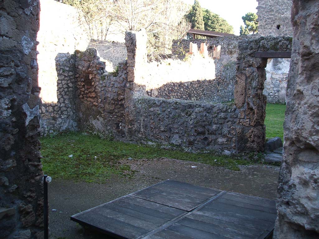 II.1.13 Pompeii. December 2004. Looking south-east from entrance into large room with window overlooking garden.
According to Jashemski, the living quarters behind the bar at II.1.1 had a small garden in the rear south-east corner.
The east wall had broken amphoras inserted in its top.
See Jashemski, W. F., 1993. The Gardens of Pompeii, Volume II: Appendices. New York: Caratzas. (p.75).

