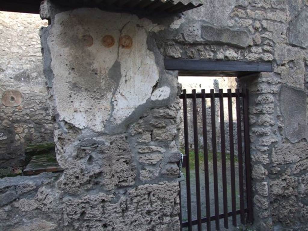 II.1.13 Pompeii. December 2007. Painted plaster on exterior wall, on north side (left) of entrance.