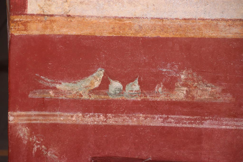 V.6.12 Pompeii. October 2024. Cubiculum 9, detail of painted bird with fruit from lower east wall. Photo courtesy of Klaus Heese.