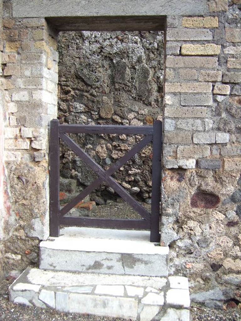 VI.1.13 Pompeii. May 2006. East wall with two marble steps and doorway leading to latrine, stable and VI.1.22.
