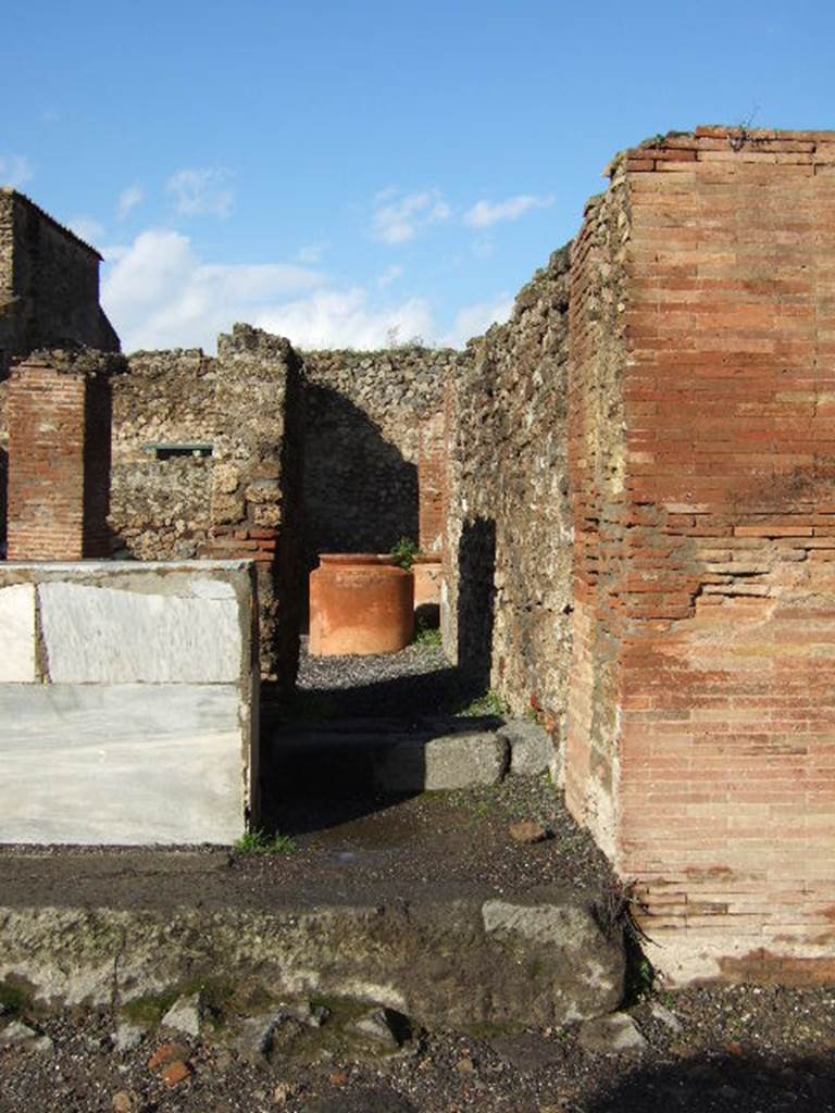 VI.8.10 Pompeii. December 2005. Looking north. According to Garcia y Garcia, there used to be a small pilaster that divided entrance 9 and 10, on the left in front of the counter. In 1943 a bomb fell on the road here, causing the destruction and loss of the pilaster. See Garcia y Garcia, L., 2006. Danni di guerra a Pompei. Rome: LErma di Bretschneider, (p.76).
According to Pagano and Prisciandaro, in March and April 1824 somewhere along the walls of the entrance 9 and 10, were found 
M(arcum) Cerrinium aed(ilem)
d(ignum) r(ei) p(ublicae) o(ro) v(os) f(aciatis) di<g=C>(nus) <e=I>s(t)    [CIL IV 264]
Licinium Faust(um)    [CIL IV 265]
written under, in red -  M(arcum) Cerrinium    [CIL IV 266]
Q(uintum) Postumium    [CIL IV 267]
L(ucium) Ceium
Secundum    [CIL IV 268]
See Pagano, M. and Prisciandaro, R., 2006. Studio sulle provenienze degli oggetti rinvenuti negli scavi borbonici del regno di Napoli.  Naples : Nicola Longobardi. (p. 129)  See PAH II,100; III, 50
