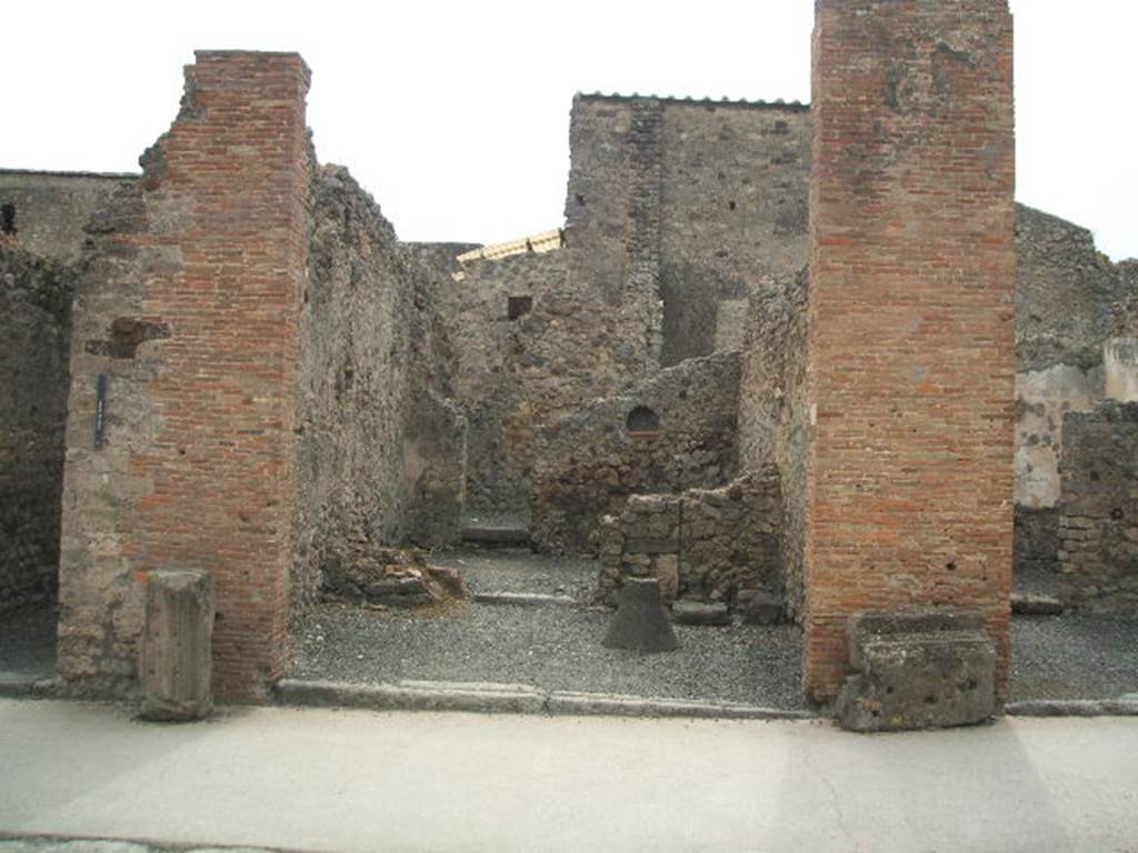 VI.8.15 Pompeii. May 2005. Entrance doorway, looking west across shop-room. On the left are the remains of the steps to the upper floor, on the south side of the doorway into the middle rear room.  Graffito was found on the pilaster on the right, between 15 and 16 (see VI.8.16)