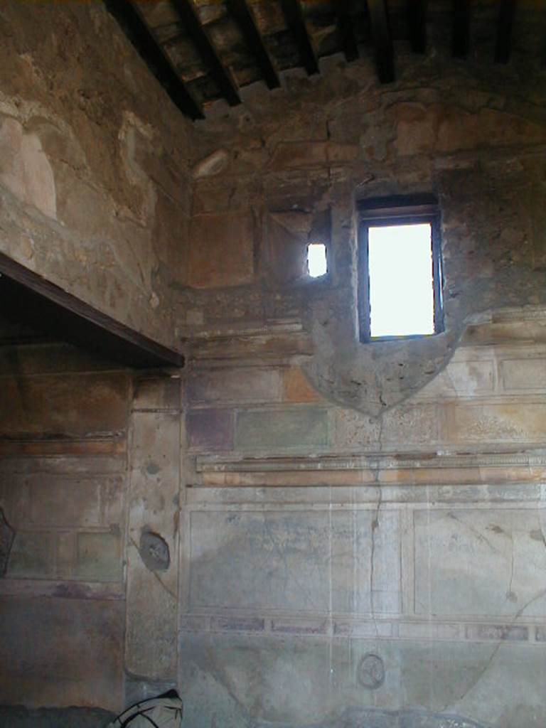 VI.9.3 Pompeii. September 2004. Cubiculum3,  on south side of entrance doorway. Looking towards the south-west corner with alcove for the bed. The small original window, partly blocked, can be seen to the left of the modern window. See Mau, A., 1907, translated by Kelsey, F. W., Pompeii: Its Life and Art. New York: Macmillan. (p. 261-2, and Fig.122)

