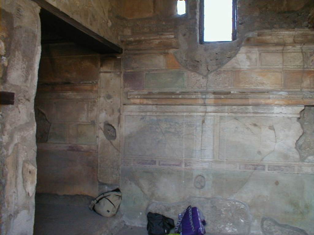 VI.9.3 Pompeii. September 2004. West wall of cubiculum 3, on south side of entrance doorway decorated in the first style.To the left is the bed alcove.