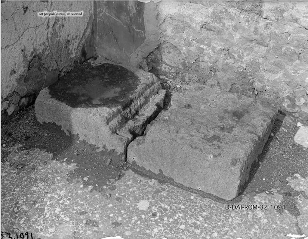 VI.12.2 Pompeii. 1932. Money chest base. Found in the north-west corner of the secondary atrium. 
According to Pernice, this was a base of a money chest made of tuff. It is narrower in the middle and has two holes in it. 
It must have broken in ancient times because it was reassembled with two dovetail clamps that no longer exist. 
Today [1932] the block is probably still in situ, broken into two pieces again.
Numerous traces of rust from the iron fittings on the surface; the centre section of the stone was so weak due to grooves and holes that it broke crosswise at one point (perhaps during its first relocation).
DAIR 32.1091. Photo © Deutsches Archäologisches Institut, Abteilung Rom, Arkiv. 
See Pernice, E., 1932. Hellenistische Tische, Zisternenmündungen, Beckenuntersätze, Altäre u. Truhen. Berlin, p. 74, Taf. 44.4.
According to Niccolini, there was a wooden chest with some bronze ornamentation, which fell apart during excavation.  
See Niccolini F, 1854. Le case ed i monumenti di Pompei: Volume Primo. Napoli, Casa del Fauno, p. 12.

