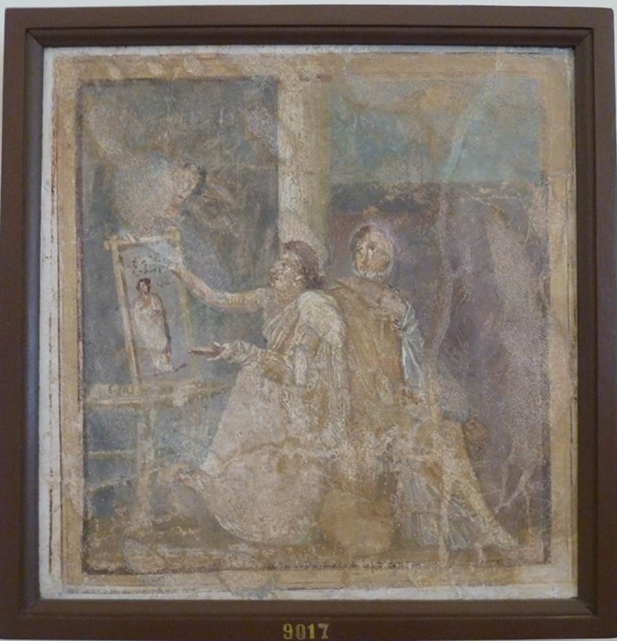VI.14.42 Pompeii.  Found in Cubiculum (3), the room on the south (or right) of the entrance corridor.   Wall painting of woman painting.  
She holds a palette in her left hand and is painting a picture on a table or easel with the right.  A woman in yellow, with a white mantel over her shoulder, sits next to her. The woman admires the painting which is of a woman in a yellow robe. Now in Naples Archaeological Museum.  Inventory number 9017. See Helbig, W., 1868. Wandgemlde der vom Vesuv verschtteten Stdte Campaniens. Leipzig: Breitkopf und Hrtel. (1444). See Richardson, L., 2000. A Catalog of Identifiable Figure Painters of Ancient Pompeii, Herculaneum. Baltimore: John Hopkins. 
(p.120, he described it as a Genre scene with woman painting a picture, found in cubiculum 3, south of fauces).
