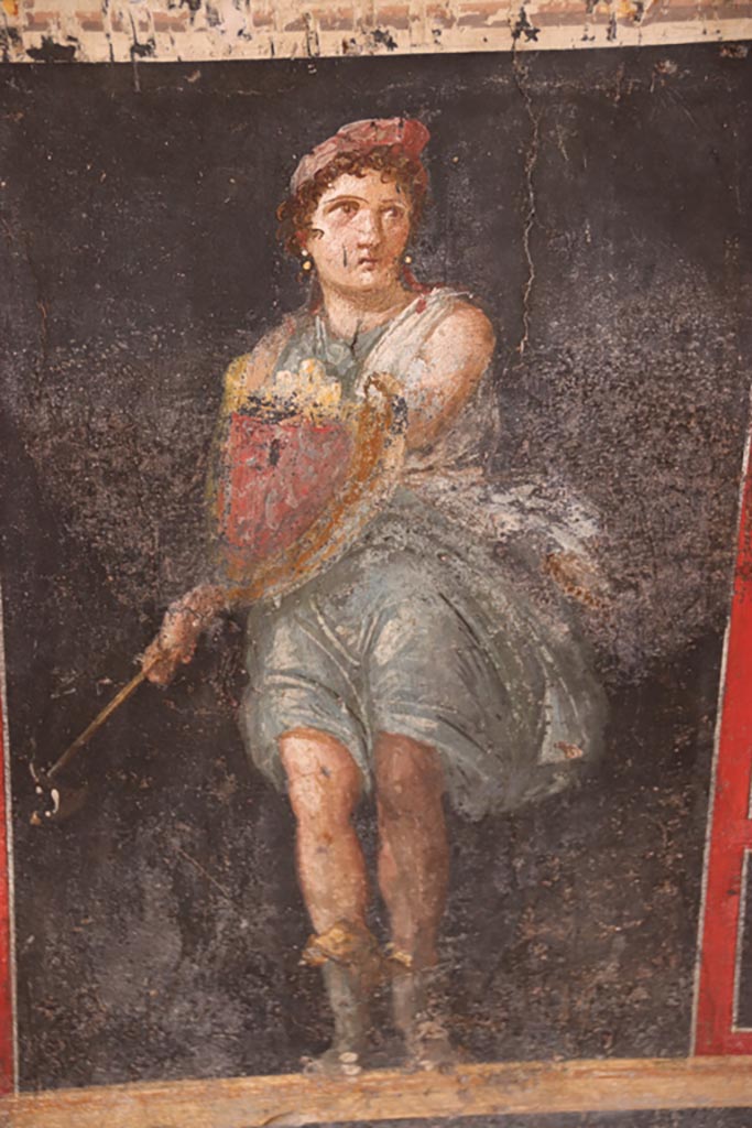 VI.15.1 Pompeii. October 2023. 
Painting of Amazon holding axe and shield from zoccolo on lower west wall. Photo courtesy of Klaus Heese.
