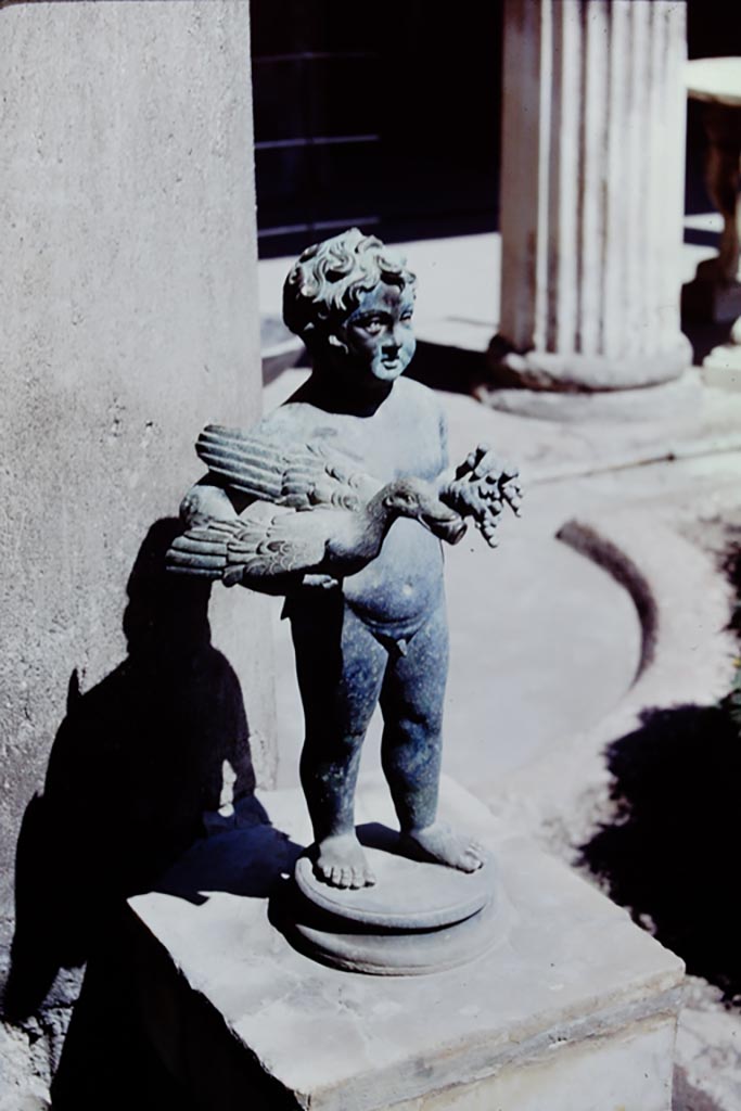 VI.15.1 Pompeii. 1968. North side of peristyle, looking east. 
Bronze garden fountain statuette of boy, bird and grapes. Photo by Stanley A. Jashemski.
Source: The Wilhelmina and Stanley A. Jashemski archive in the University of Maryland Library, Special Collections (See collection page) and made available under the Creative Commons Attribution-Non-Commercial License v.4. See Licence and use details.
J68f1964
