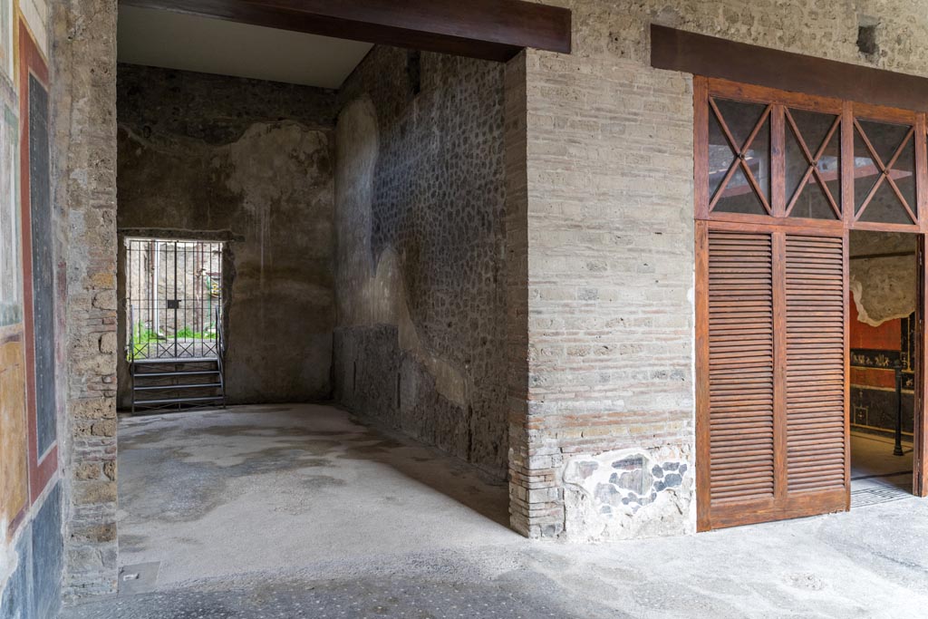 VI.15.1 Pompeii. March 2023. Looking north in room, on left, in north-west corner of peristyle. (PPM – room r).
On the right is the doorway to the “Cupids’ room”, (PPM - room q).  Photo courtesy of Johannes Eber.
