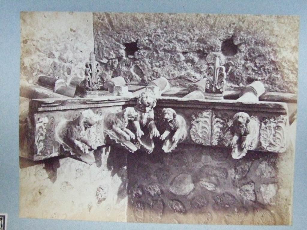 Cornice in terracotta of a Compluvium preserved at Pompeii.  
Old photograph courtesy of Society of Antiquaries, Fox Collection.
These are Grondaia or rainwater spouts that fed rainwater from the Compluvium in the roof to the Impluvium below.   These were reconstructed and displayed during the 19th century in VII.4.15/16 before the Antiquarium was opened. Mau says they were originally from a House near the Porta Marina,  The plan provided by Mau can be used to identify the house as VII.16.12/15 the House of Umbricius Scaurus. See Mau, A., 1907, translated by Kelsey F. W. Pompeii: Its Life and Art. New York: Macmillan. (p.251, p.253, p.298).