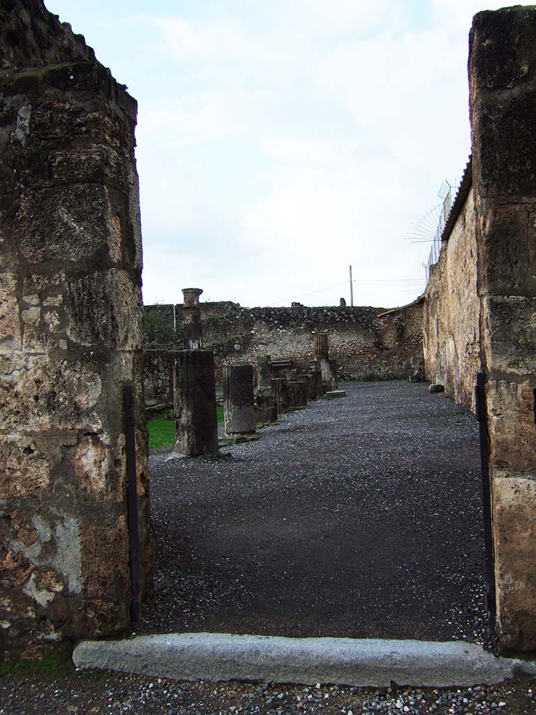 VII.7.32 Pompeii. December 2005. Entrance doorway to Temple of Apollo on west side of Forum.
According to Gell –
“Entrance to the enclosure of a temple. It may also be approached from the Forum by other openings. No name has hitherto, with sufficient authority, been applied to this edifice. On the spot, a portion of a female statue, found therein, has induced the excavators to assign it to Venus; while the pictures found within its enclosure do not afford much better ground for supposing it of any other divinity. Around the walls of the porticoes, at 2 feet 6 inches from the ground, runs a series of paintings, of dwarfs and architectural subjects. In one corner is a painting of Achilles and Agamemnon: in another Hector tied to the chariot of Achilles: and in an apartment is a picture of Bacchus and Silenus.”
See Gell, W, and Gandy J. P., 1821. Pompeiana: 2nd edition. London: Rodwell and Martin, (p.216-217).
