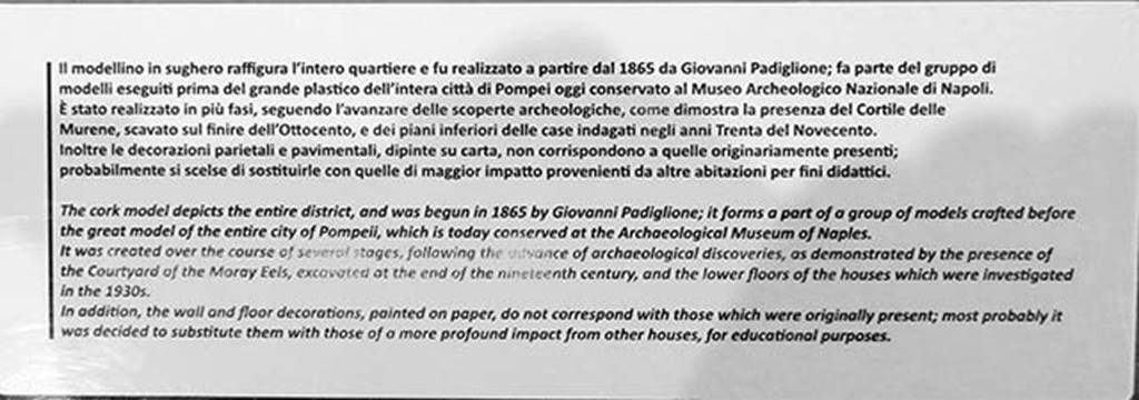 VIII.2.14/16 Pompeii. May 2018. Information notice on the cork model.
Photo courtesy of Buzz Ferebee.
According to the Archaeological Park of Pompeii display notice –
The cork model was begun in 1865 by Giovanni Padiglione, one of several models predating the great model of the entire city now in Naples Archaeological Museum. 
It was created over the course of several stages, following the advance of archaeological discoveries, as demonstrated by the Courtyard of the Moray Eels, excavated at the end of the nineteenth century, and the lower floors of the houses which were investigated in the 1930’s.
In addition, the wall and floor decorations, painted on paper, do not correspond with those that were originally present; most probably it was decided to substitute them with those of a more profound impact from other houses, for educational purposes.
