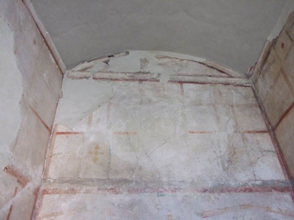 VIII.4.4 Pompeii. March 2009. Room 22, upper west wall, with vaulted ceiling of cubiculum.
The wall was painted white up until the height of the vault and edged by a stucco cornice.
According to Sogliano –
“Le pareti a fondo bianco animate da numerosi quadretti con ritratti, la cornicetta di stucco bianco con piani d’ombra a tinta pavonazzetta alla sommita dei muri, l’incavo profondo e caratteristico per il letto nel muro a sinistra, tutto l’insieme rese questo grazioso cubicolo meritevole della protezione di una tettoia.”
(The walls with a white background enlivened by numerous paintings with portraits, the white stucco cornice with peacock-hued shades at the top of the walls, the deep and characteristic recess for the bed in the wall on the left, the whole made this graceful cubiculum/bedroom worthy of the protection of a canopy/roof.)
See Sogliano, A. Dei lavori eseguiti in Pompei dal 1 luglio 1908 a tutto Giugno 1909. (p.11).

