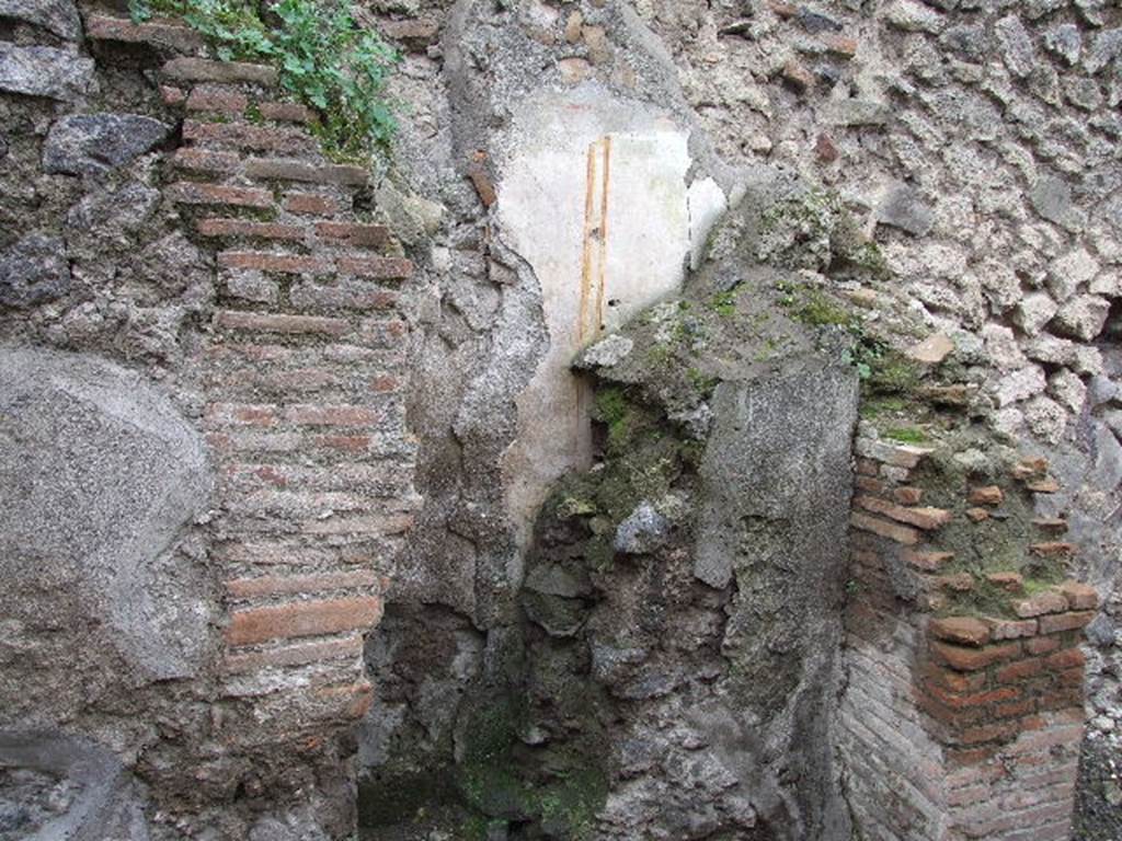 VIII.4.11 Pompeii. December 2006. Wall plaster behind later wall, on west side of shop.