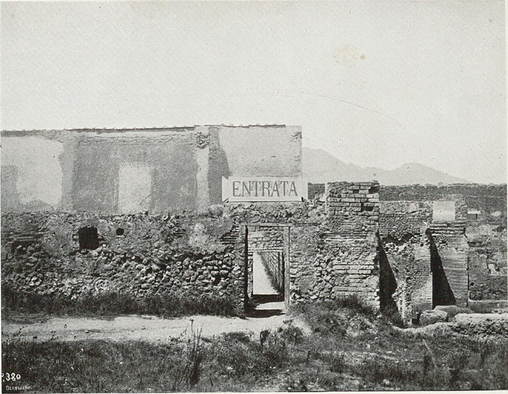 VIII.7.16 Pompeii. c.1907-1908. Photograph titled “Attuale entrata dal ludo gladiatorio”.
Looking north towards entrance doorway into small room at exterior south-east corner of Gladiator’s Barracks.
This would have been an original entry to excavations of Pompeii.
According to Sogliano –
“………..and the very petty and inconvenient entry into Pompeii, made a few years ago, from a narrow corner of the Ludo Gladiatorium.  I will take care of this last filthy situation immediately, transferring the entrance to the Porta di Stabia, in the same way as one accesses the excavations by the Porta Marina and the Porta Nola.”
See Sogliano, A. (1908). Dei lavori eseguiti in Pompei dal 1 Aprile 1907 a tutto Giugno 1908. (p. 16 and fig.7).

