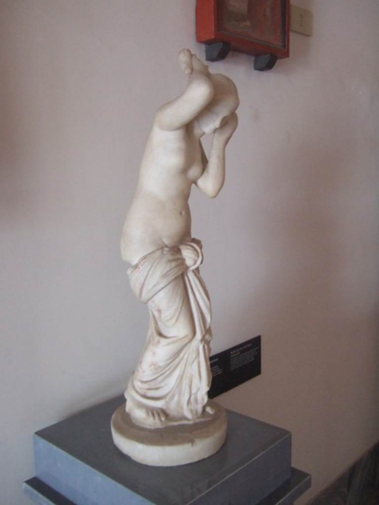 VIII.7.28 Pompeii. Marble statue of Venus Anadyomene (Venus drying her hair after a bath). 
Found against the west wall of the colonnade in the south west corner.
Now in Naples Archaeological Museum. Inventory number 6298.
