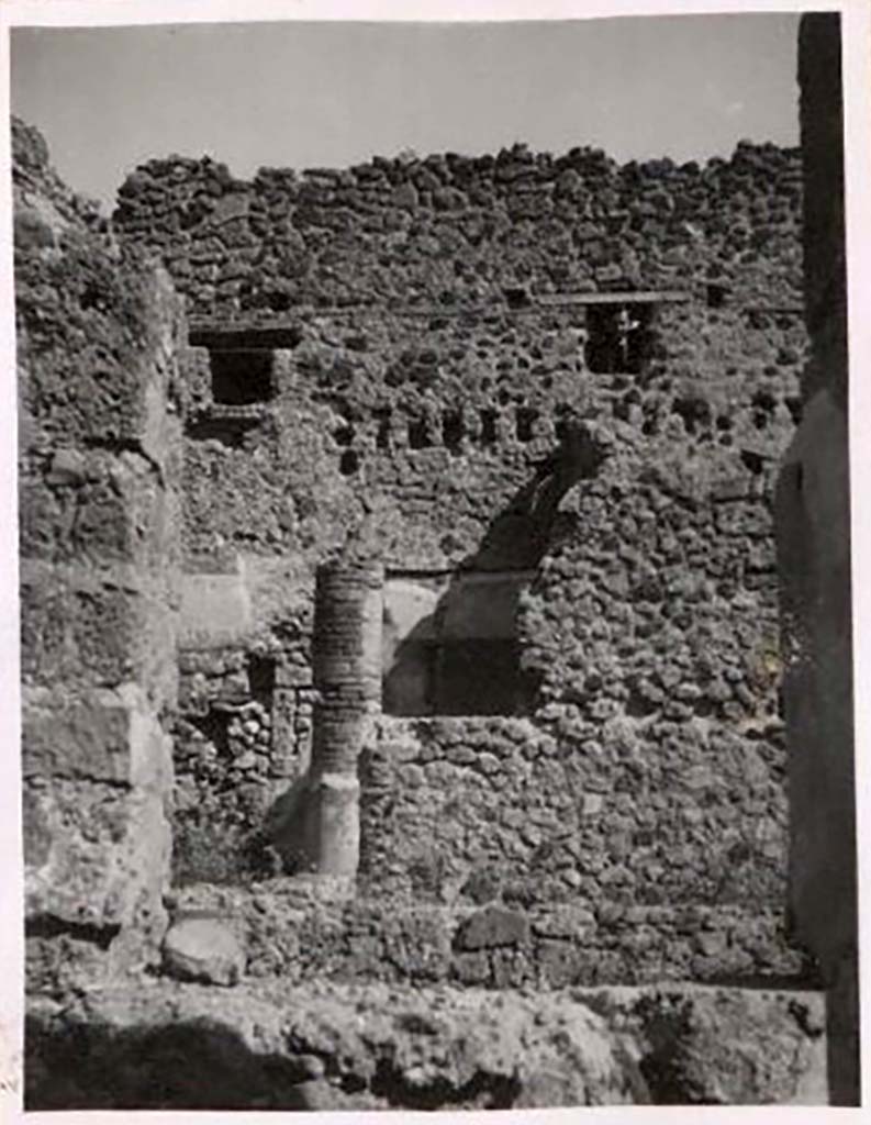 IX.1.12 Pompeii. Pre-1943. Photo by Tatiana Warscher.
Looking across peristyle towards doorway to cubiculum in north-east corner of peristyle.
According to Warscher, the rear (east) wall had rectangular holes for support beams which demonstrated that there were rooms on an upper floor.
These rooms would have received light through windows from IX.1.20.
See Warscher, T. Codex Topographicus Pompeianus, IX.1. (1943), Swedish Institute, Rome. (no.52), p. 82.