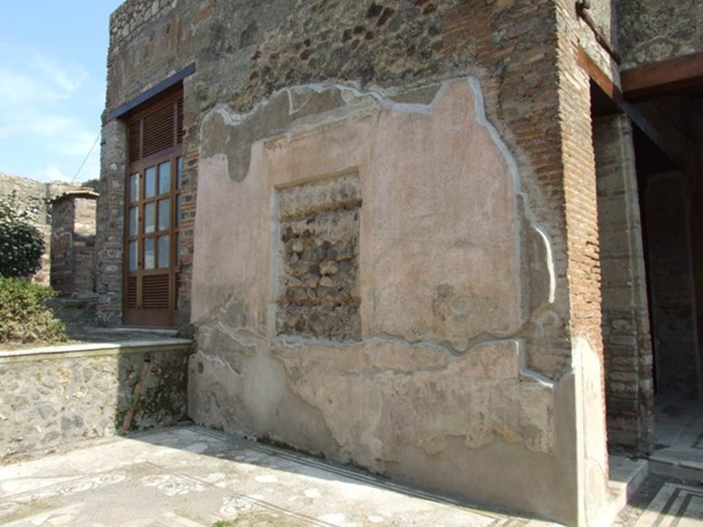 IX.3.5 Pompeii. March 2009. Room 12, south wall of tablinum.  According to Dyer:
“The tablinum was raised by one step above the floor of the atrium. Its floor consists of a white marble mosaic, surrounded with narrow black borders. In the middle is a slab of giallo antico, encircled with a border of variegated mosaic.  The walls are richly decorated with pieces of architecture, and in the middle of them are spaces for two large pictures, which must have been removed before the eruption. The wooden frames in which the pictures were contained have left their impressions on the stucco, as well as the marks of two horizontal supports at the back of them. These marks, which are about two inches deep, have led some writers to suppose that the pictures were painted on wood. Whether, however, there were any such at Pompeii is a moot point; and Overbeck contends that the supports at the back might have served either for a thin stucco tablet or to bind together the pieces of a wooden one. The ceiling of the tablinum was also of stucco, with coloured panels and gilt rosettes in the centre of them, as appears from numerous fragments which were discovered.”
See Dyer, T., 1867. The Ruins of Pompeii. London: Bell and Daldy. (p.84)
