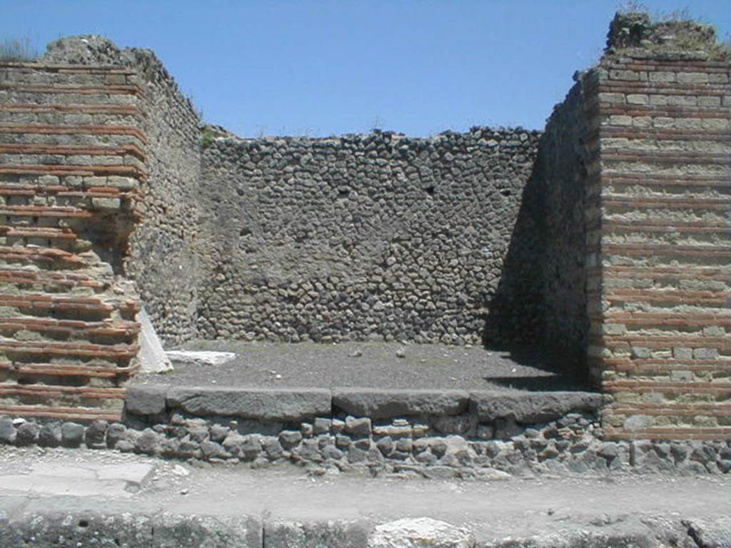 IX.4.2 Pompeii. May 2005. Looking east towards entrance on Via Stabiana.
According to Maiuri, three of the shops on the corner of this insula, appear to have had an elevated threshold of at least 0.80m above the floor of the sidewalk and what should have been the original threshold. They clearly distinguish the brickwork/masonry of the above elevation from the original floor of the threshold. In the third taberna (from the corner of the quadrivium) IX.4.3, only one block of the threshold appears located in its place.
See Maiuri, A, (2002): Lultima fase edilizia di Pompei, Arte Tipografica, Naples, (p.75, note 3).


