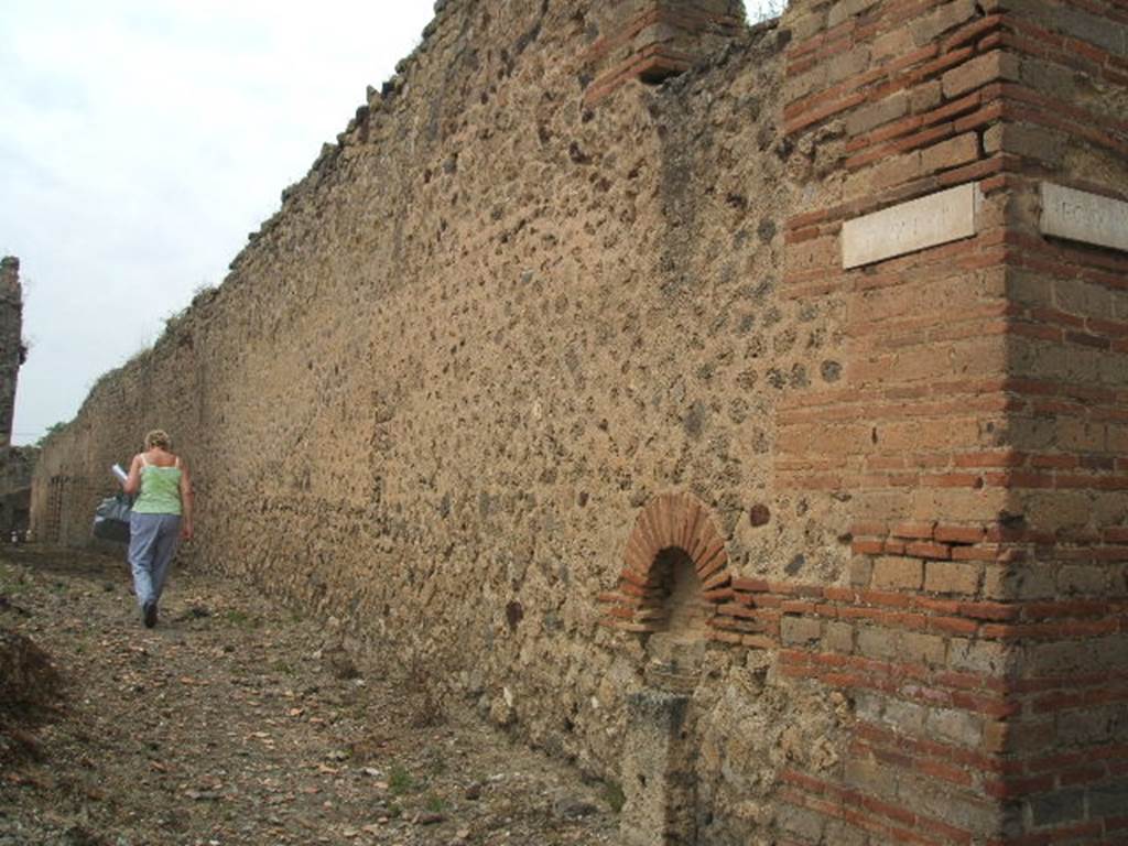 Unnamed Vicolo with exterior wall and Lares Compitales of Central Baths. Looking west between IX.4.14 and IX.4.15.
