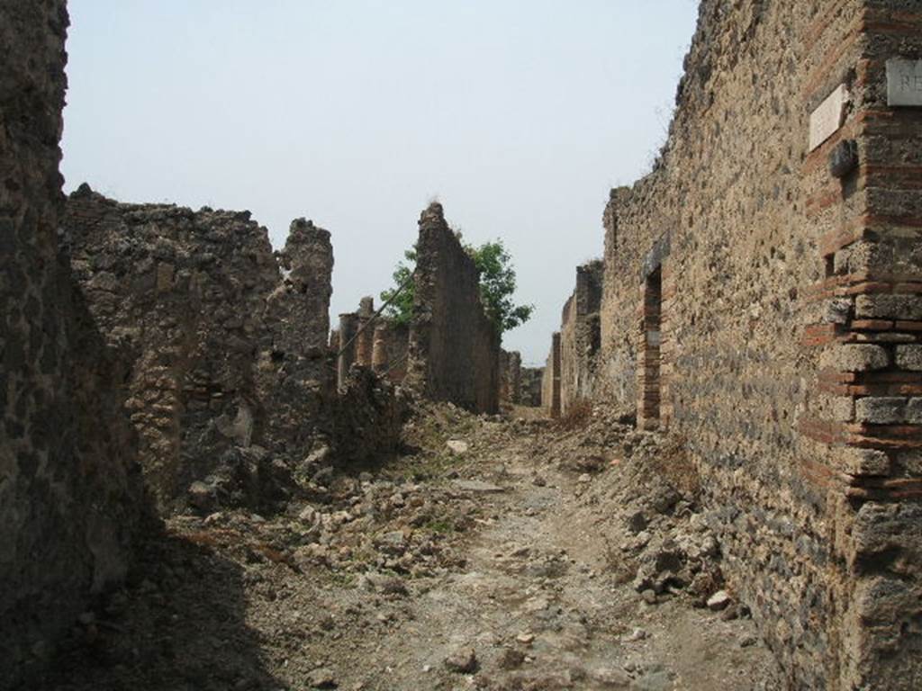 IX.6.8 (North exterior wall), on left. May 2005. Unnamed vicolo looking west. Corner of IX.5, on right.