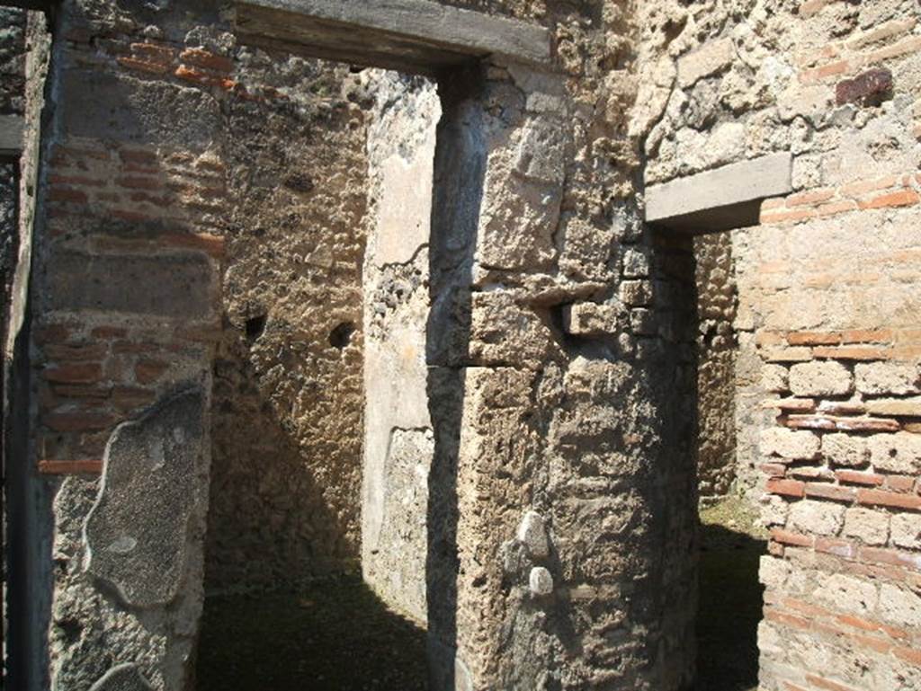 IX.7.20 Pompeii. May 2005. 
Looking west through doorway to small room (b) or cupboard on north side of street entrance doorway.
On the right of the photo is the doorway to room (a) with stairs to upper floor.
